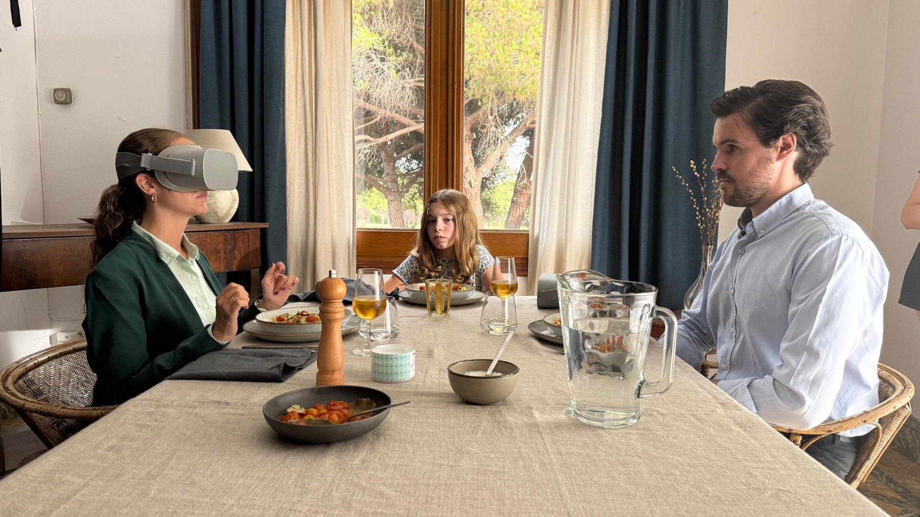 Family dinner, the mother wears a VR headset